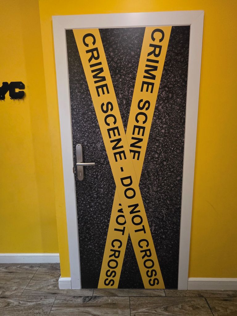 Originell gestaltete Tür mit „Crime Scene“-Motiv im World Hostel Old Town in Danzig.