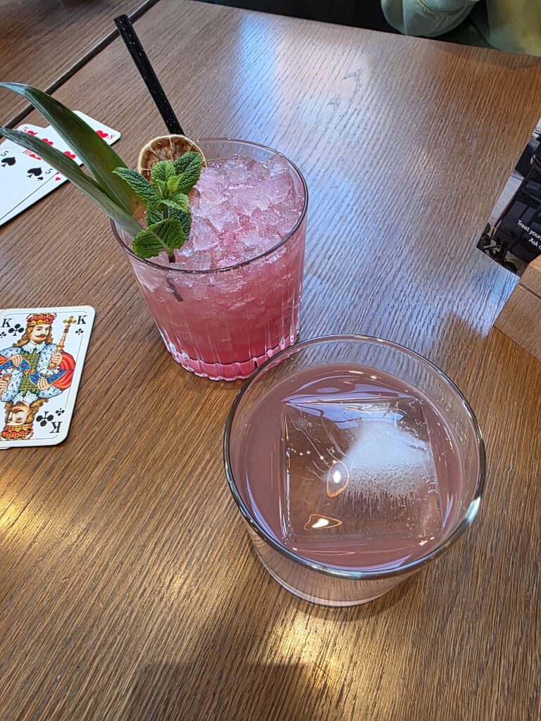 Zwei Drinks und Spielkarten beim gemütlichen Rommé-Abend im Hotel in Stockholm.