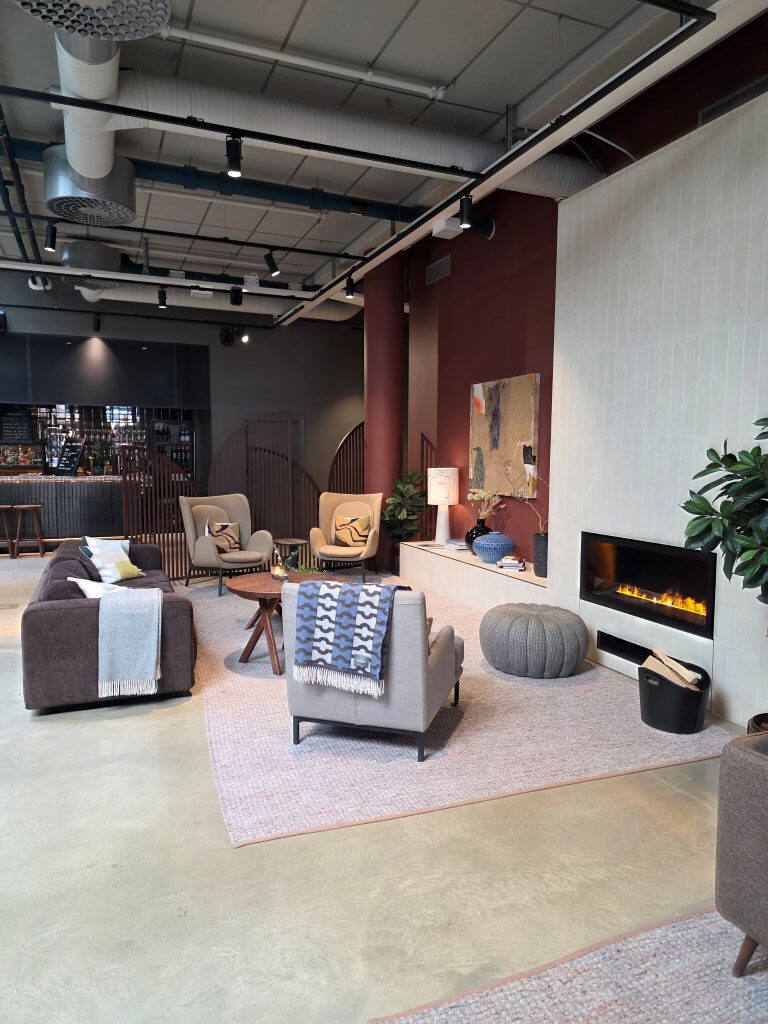 Gemütliche Lounge mit Sesseln, Sofas und Kamin im Home Hotel Tapetfabriken.