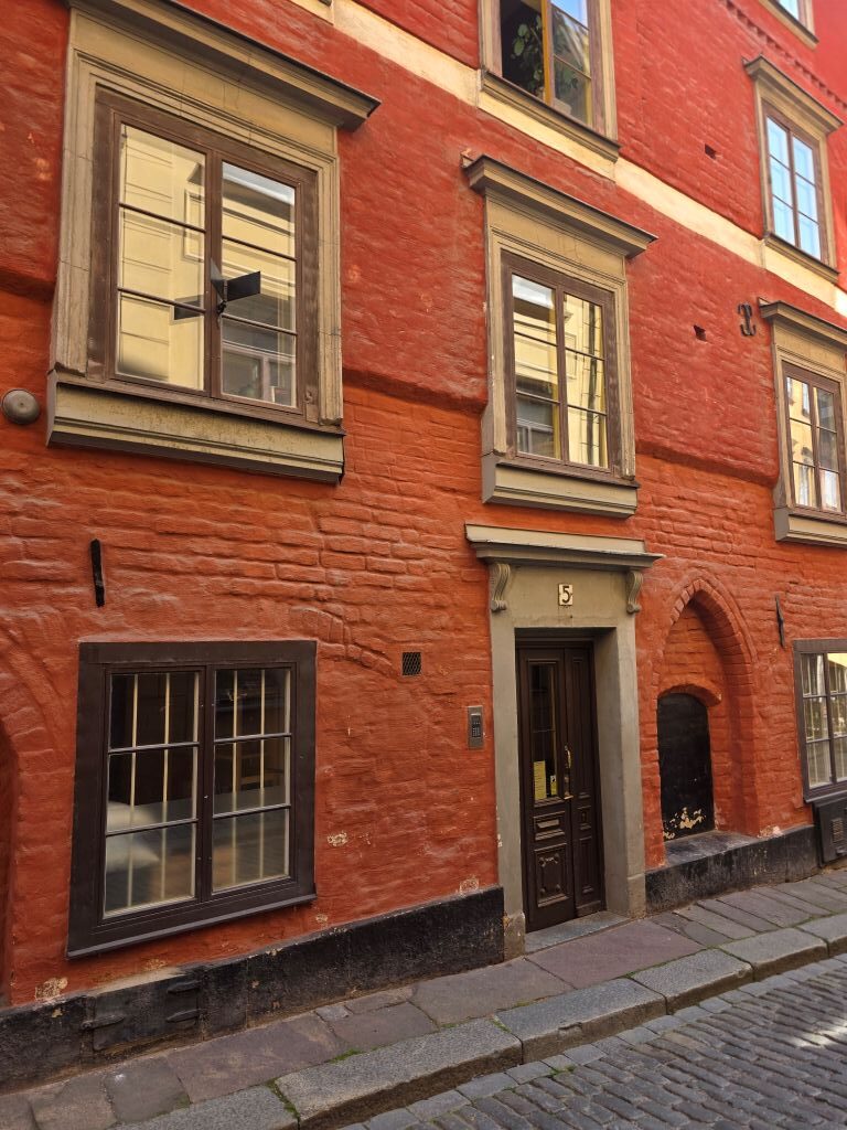 Historische rote Hausfassade mit alten Fenstern und Eingang in Gamla Stan in Stockholm.