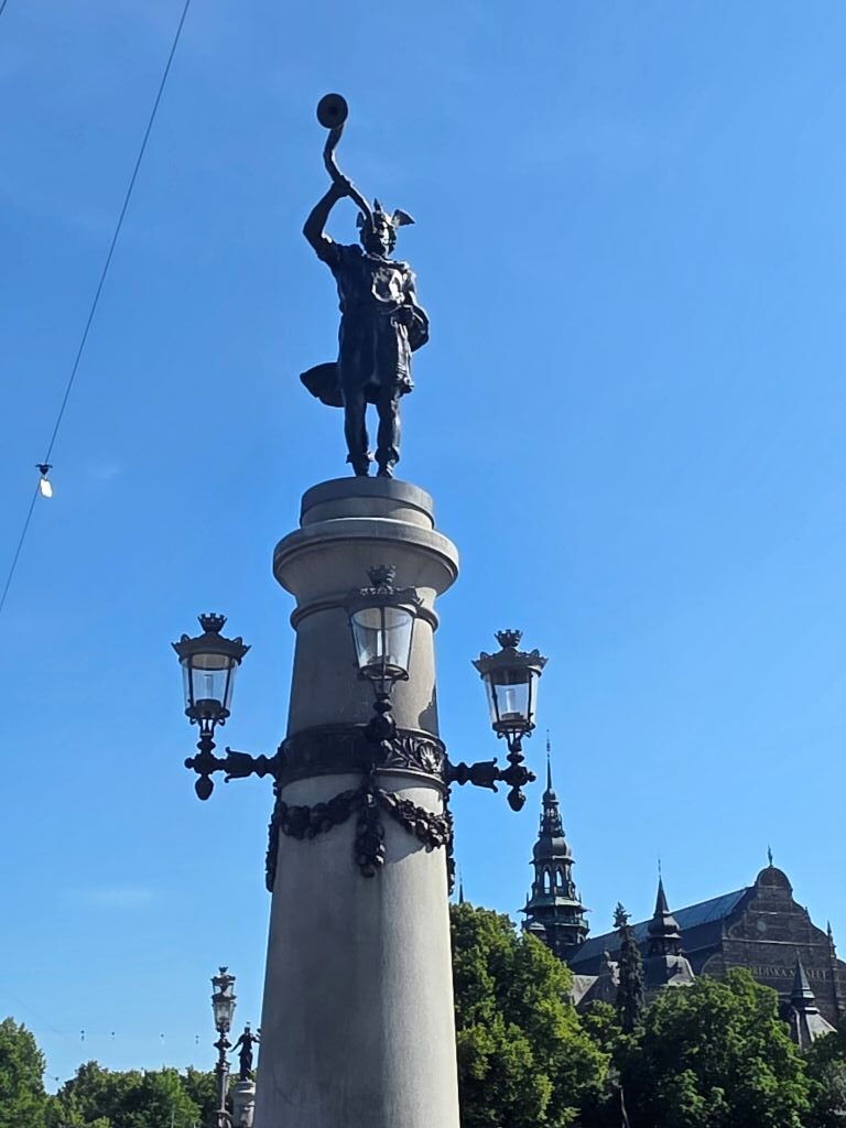 Statue auf einer hohen Säule vor blauem Himmel in Stockholm.