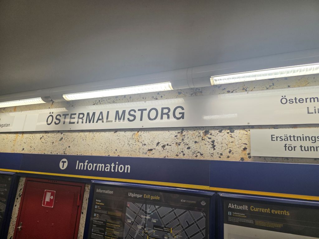 U-Bahn-Station Östermalmstorg in Stockholm mit Stationsschild und Informationstafeln.