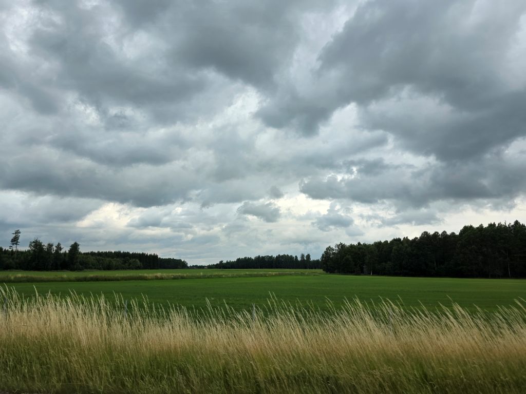 Dunkle Regenwolken über Feldern und Wiesen während unseres Schweden-Roadtrips