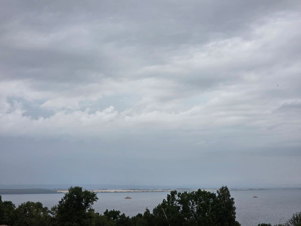 Weiter Blick über einen See in Schweden bei dicht bewölktem Himmel