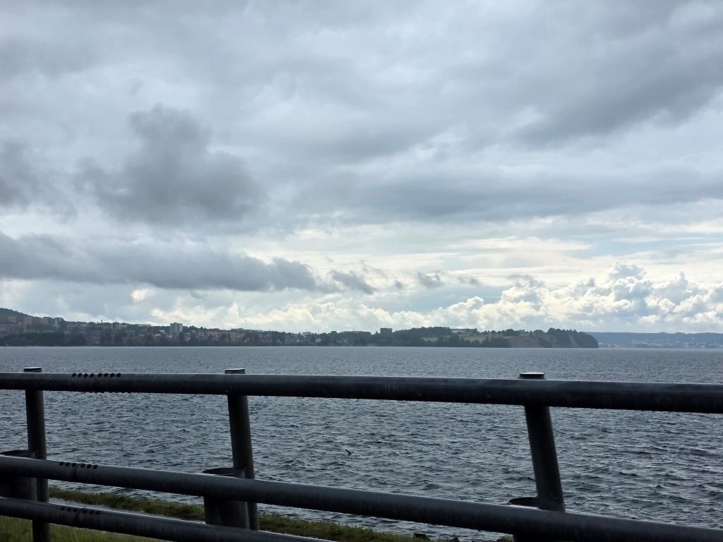 Schwedische Landschaft mit Wiesen und ersten blauen Stellen zwischen den Wolken