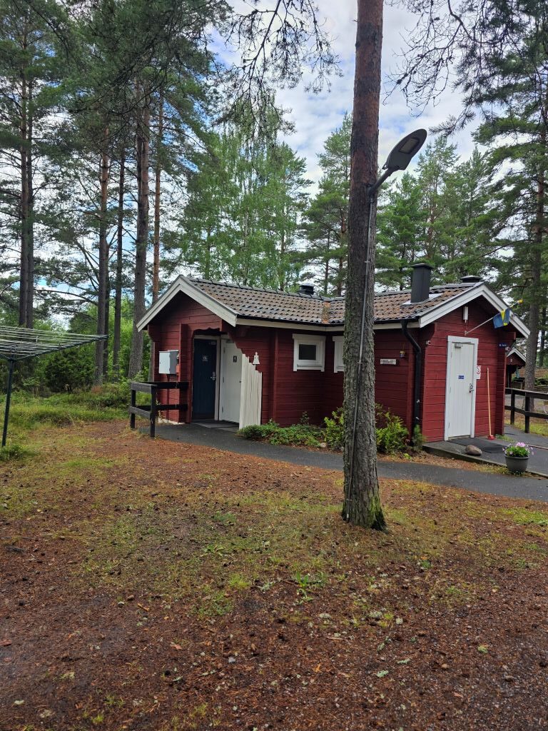 Gemeinschaftsgebäude zwischen hohen Kiefern im Hyltena Stugby bei Jönköping