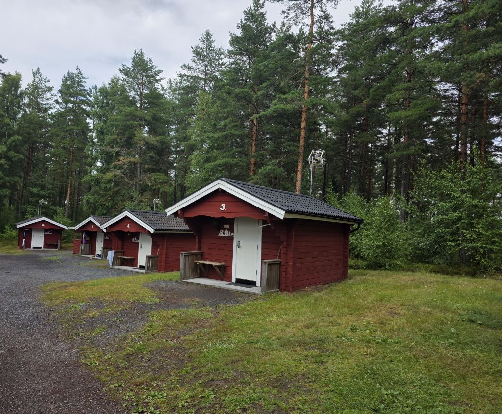 Kleine rote Holzhütten des Hyltena Stugby mitten im schwedischen Wald