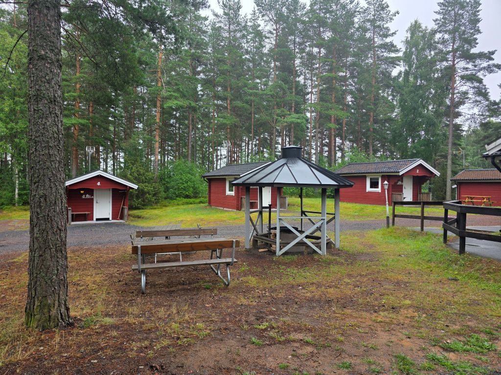 Kleine rote Schwedenhütten und überdachter Sitzplatz im Hyltena Stugby