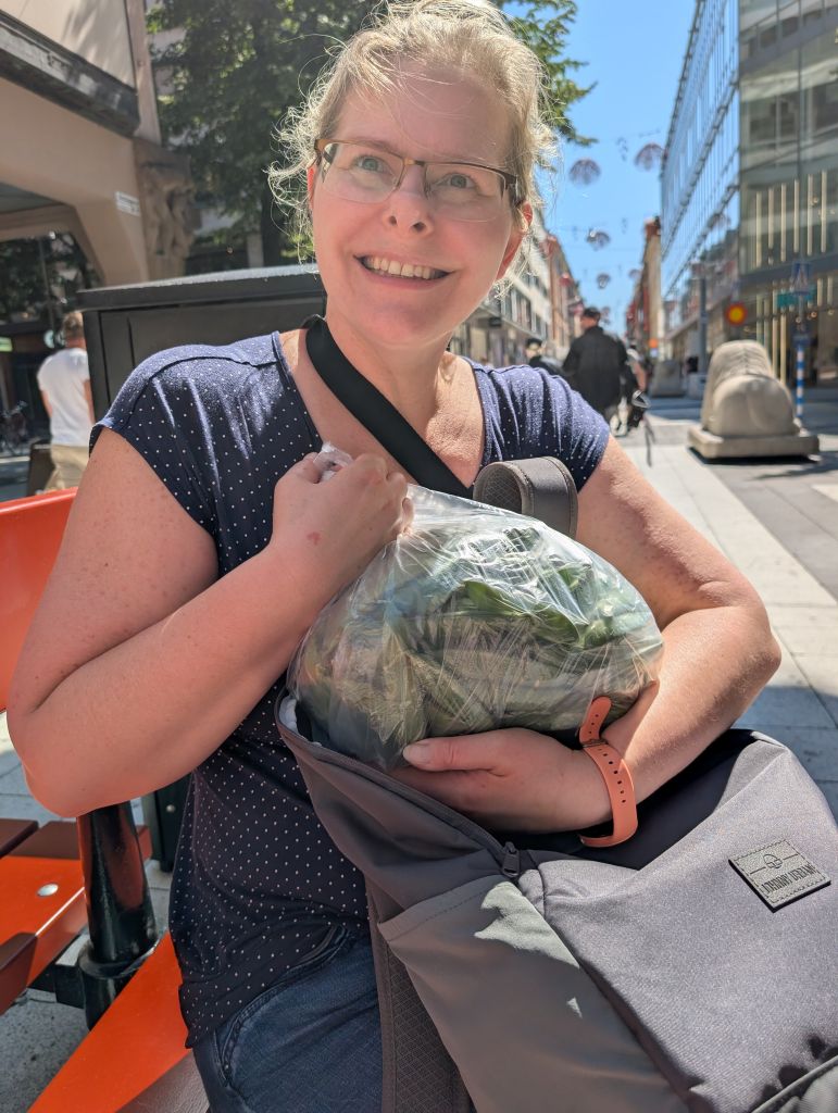 Frau mit einer großen Tüte frischer Erbsen beim Stadtbummel durch Stockholm.