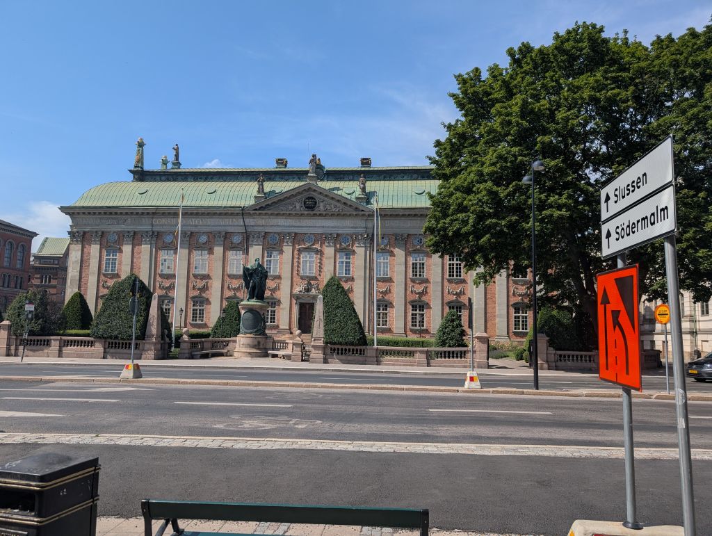 Historisches Riddarhuset in Stockholm mit Wegweisern Richtung Slussen und Södermalm.