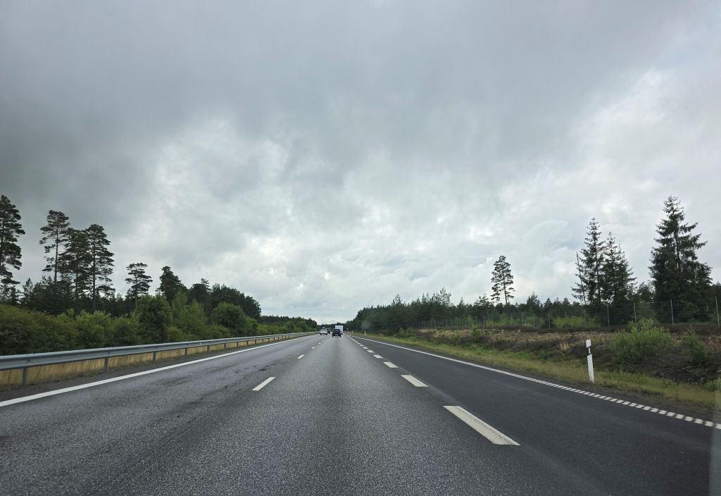 Fahrt auf der schwedischen Autobahn unter dunklen Regenwolken auf dem Weg zum Elchpark.