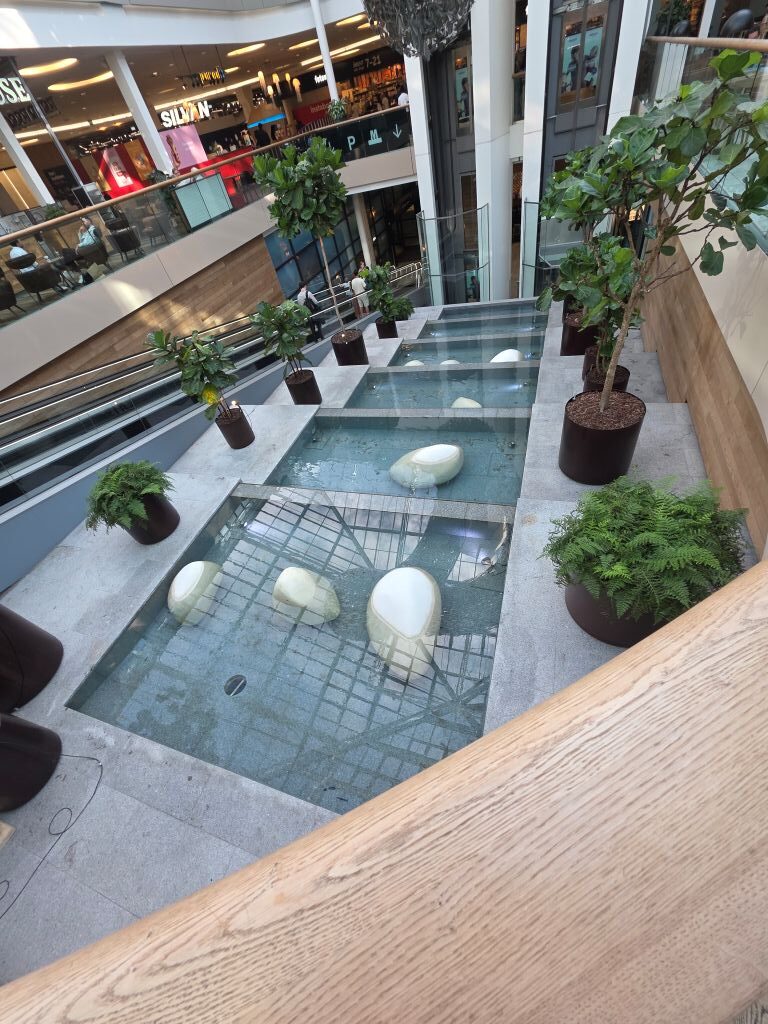 Wasserbecken und Pflanzen im modernen Innenbereich des Fisketorvet Copenhagen Mall