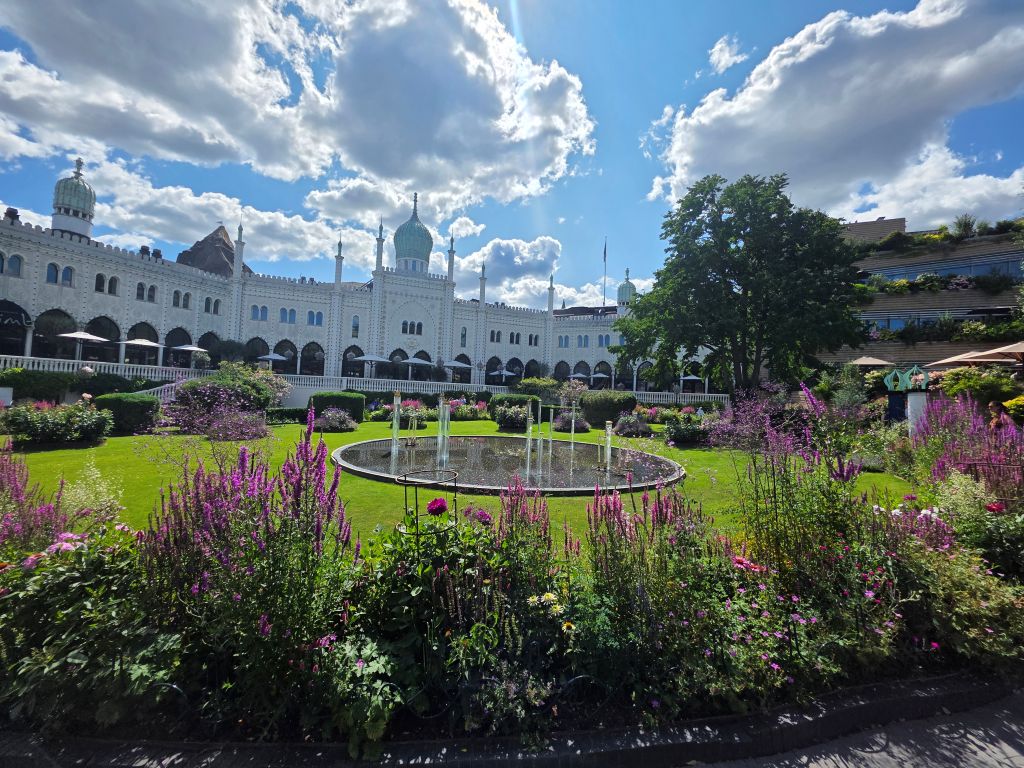 Blühender Garten mit Springbrunnen und orientalischem Gebäude im Tivoli Kopenhagen.