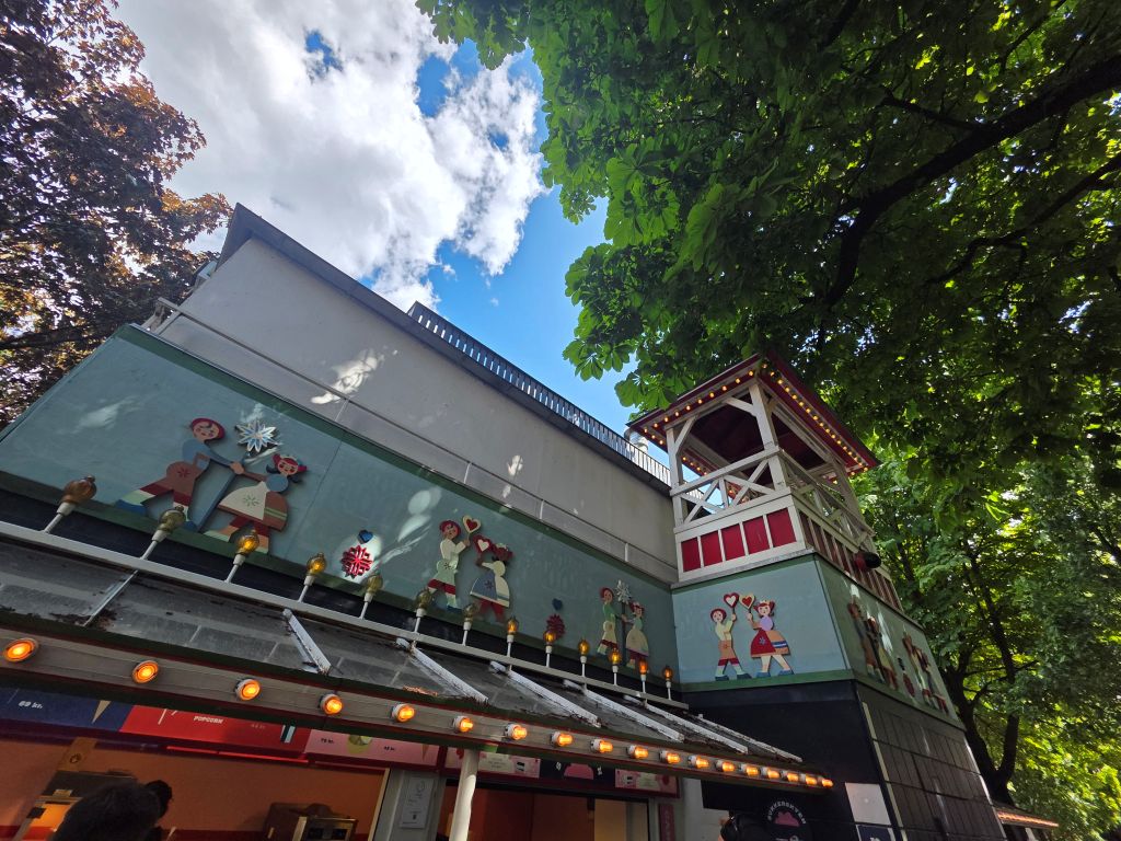 1. Liebevoll gestaltetes Gebäude unter großen Bäumen im Tivoli Kopenhagen.