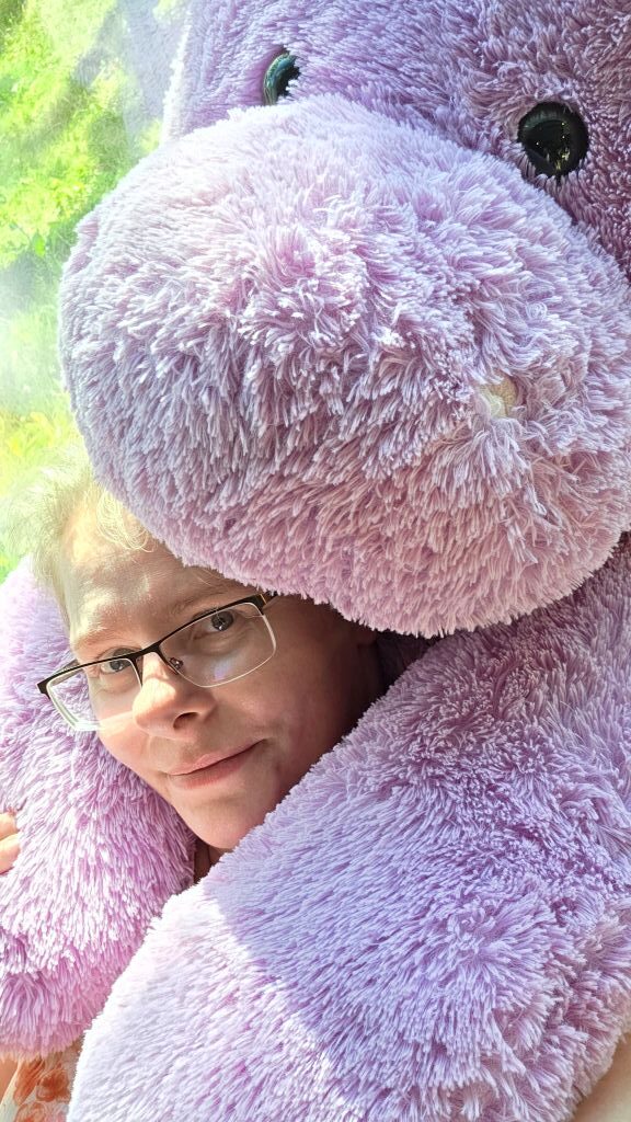Kuscheliges Erinnerungsfoto mit einem riesigen lilafarbenen Plüsch-Nilpferd.