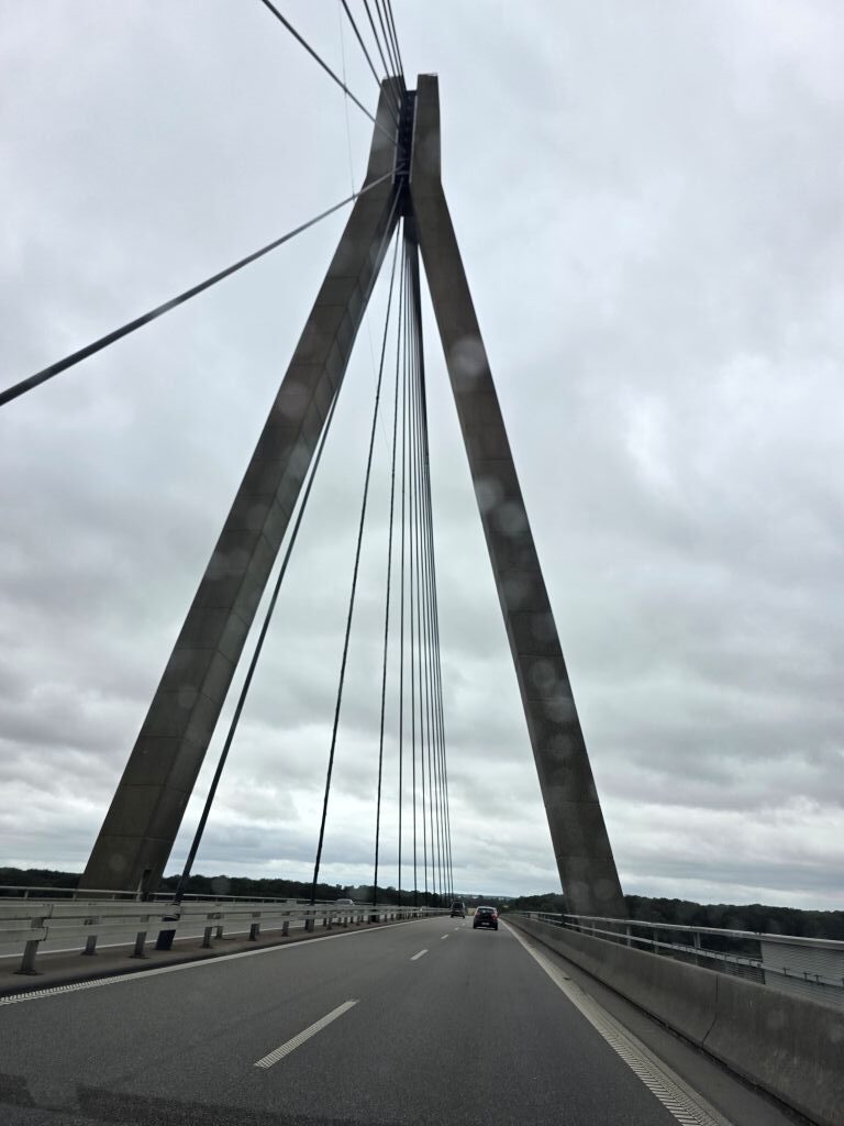 Fahrt über eine große Brücke in Dänemark bei grauem Regenwetter.