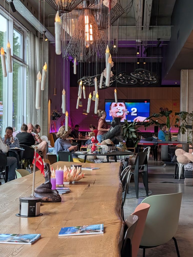 Lobby des Moxy Copenhagen Sydhavnen mit großer Leinwand beim gemeinsamen Fußballschauen