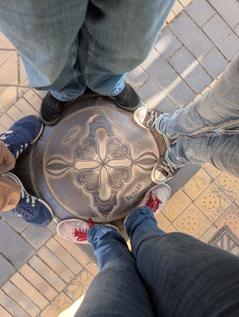 Unsere vier Paar Schuhe rund um ein Tivoli-Emblem im Freizeitpark in Kopenhagen.
