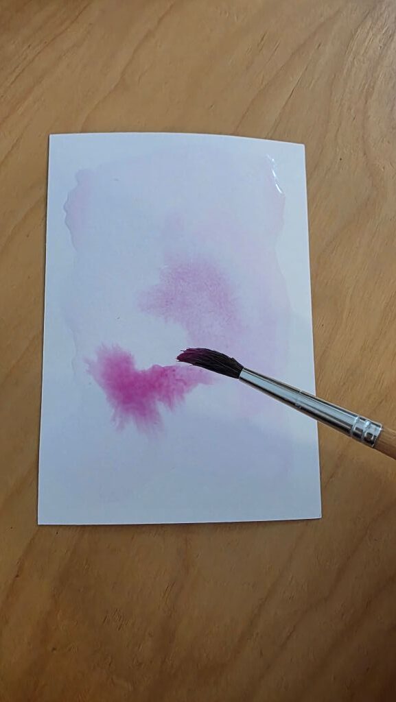 Gestaltung des Aquarellhintergrunds mit rosa Wasserfarbe und Pinsel für die Einladung zur Konfirmation.