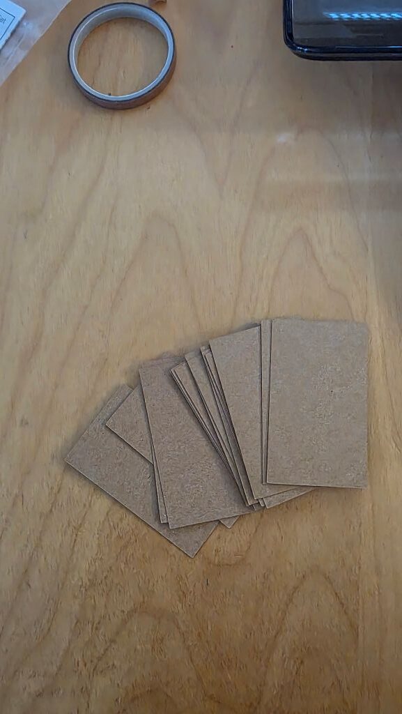 Zugeschnittene Rechtecke aus Kraftpapier für die selbst gemachten Einladungskarten zur Konfirmation.
