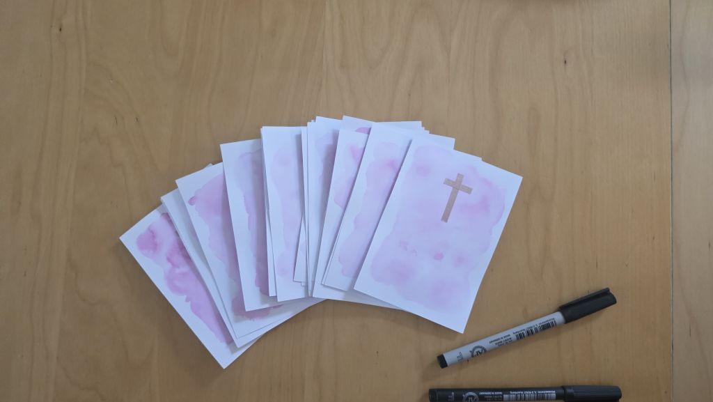 Vorbereitete Konfirmationskarten mit rosa Aquarellhintergrund und aufgeklebtem Kreuz aus Washi Tape.