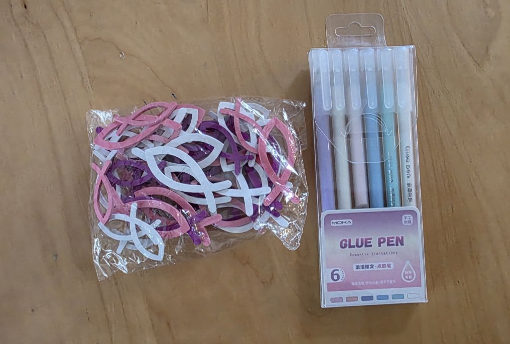 Kleine Fische und Klebestifte zum Basteln und Verzieren der Einladungskarten zur Konfirmation.